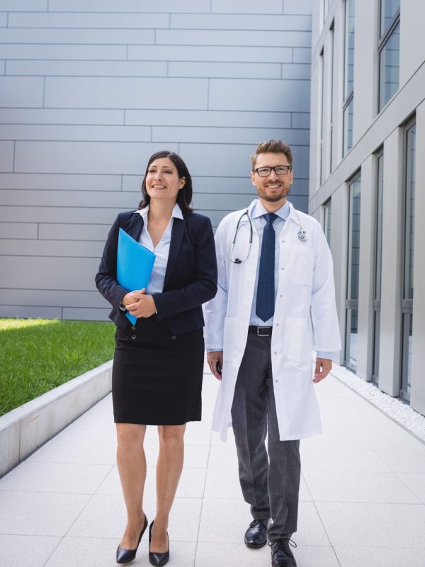 Smiling doctors walking together in hospital premises Smiling doctors walking together in hospital premises
